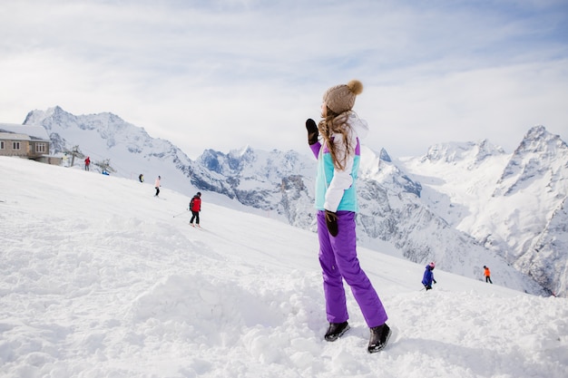 Ragazza in un vestito di inverno che sorride nelle montagne