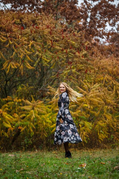 Ragazza in un vestito nella foresta d'autunno