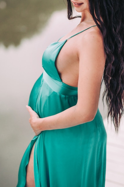 Ragazza in un vestito verde di ottavo mese