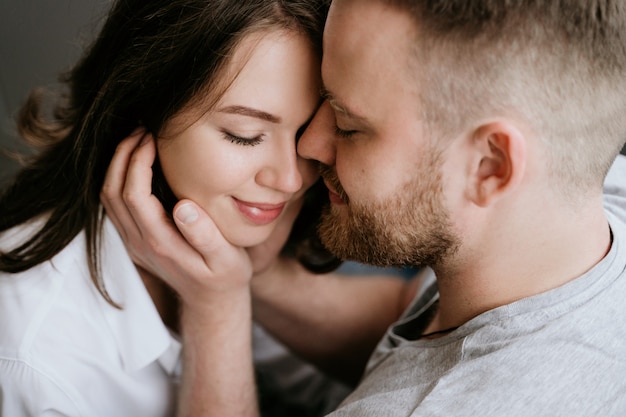 Ragazza in una camicia bianca e un ragazzo in una maglietta grigia. Baci e abbracci.