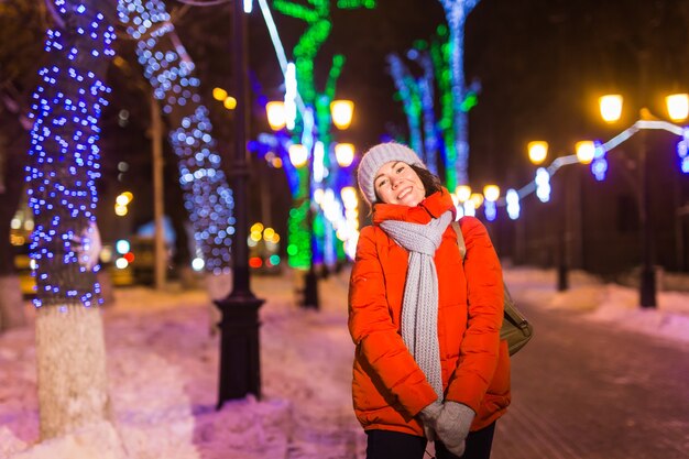 Ragazza in una città di notte fiocco di neve natale luci della città natale e vacanze invernali concept