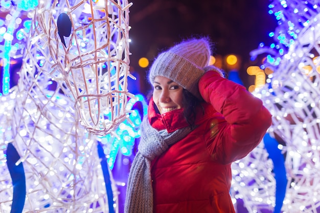 Ragazza in una città di notte fiocco di neve natale luci della città natale e vacanze invernali concept