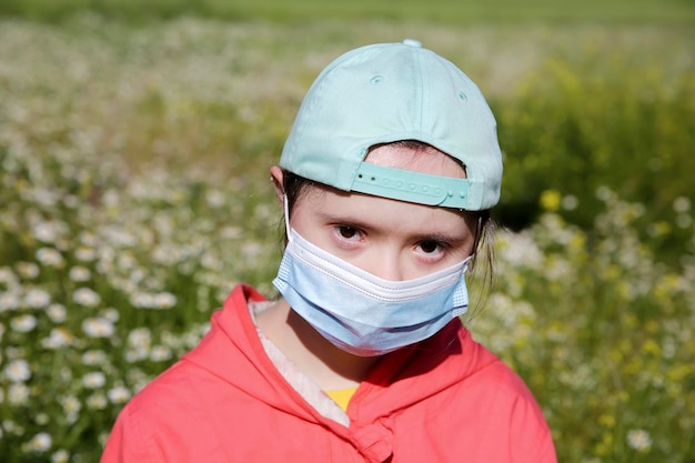 Ragazza in una maschera sul viso sullo sfondo del campo di fiori