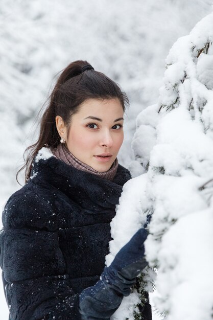 Ragazza in una pelliccia in un bosco innevato