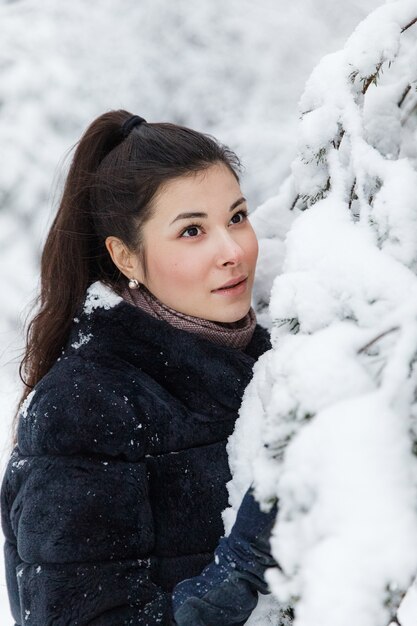 Ragazza in una pelliccia in un bosco innevato