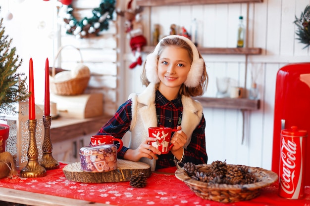 Ragazza in una stanza con albero di Natale e decorazioni