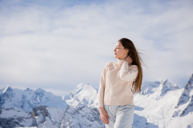 ragazza in una tuta invernale guardando le montagne