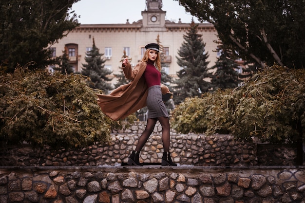 Ragazza in vestiti alla moda di autunno nel parco