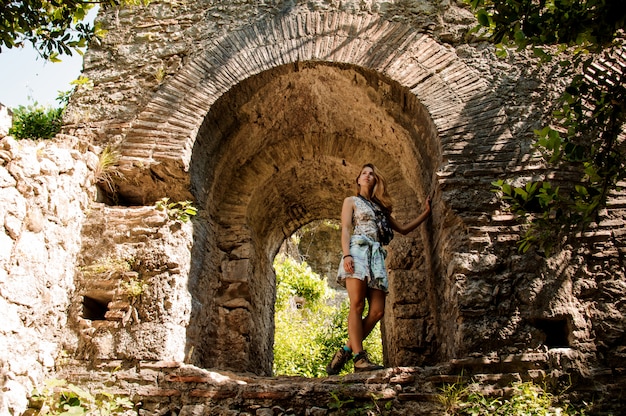 Ragazza in vestito chiaro sotto il vecchio arco