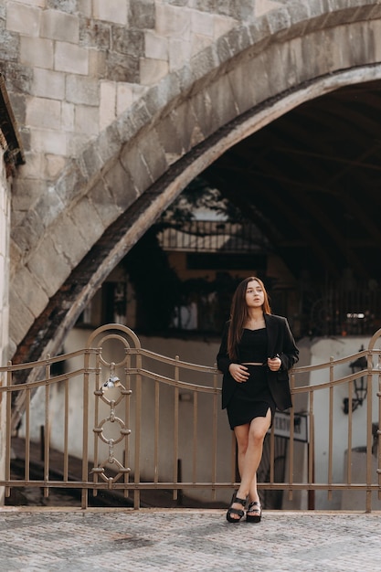 Ragazza in vestito nero che cammina nella città vecchia