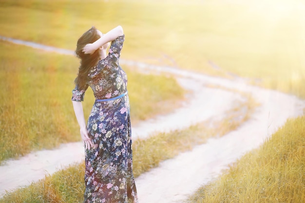 Ragazza incinta in un vestito in natura