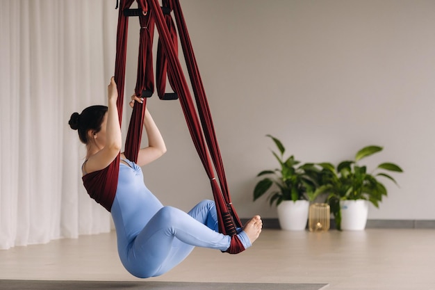 Ragazza incinta Una donna fa yoga su un'amaca in palestra Il concetto di uno stile di vita sano Maternità