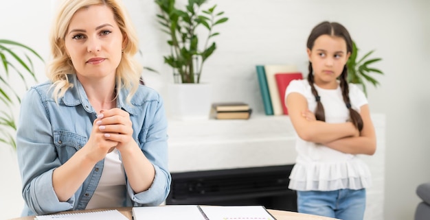 Ragazza infelice che non parla dopo una discussione con la madre nel soggiorno di casa.