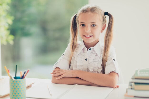 Ragazza intelligente che va a casa alla scrivania a casa