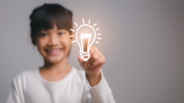 Ragazza intelligente del bambino con il concetto di scuola di concetto di idea della lampadina