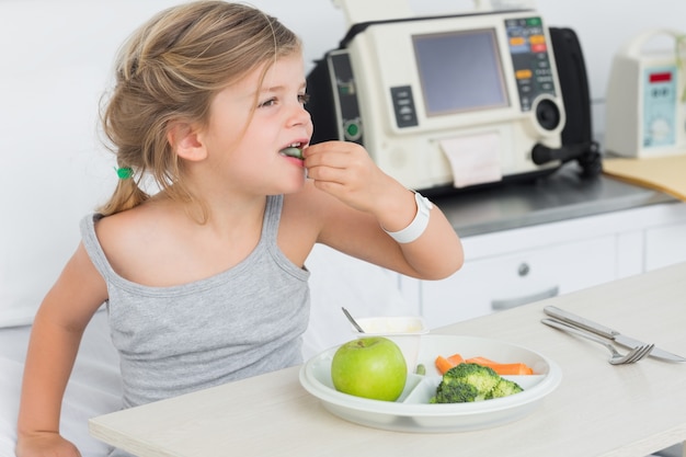 Ragazza malata che mangia cibo sano