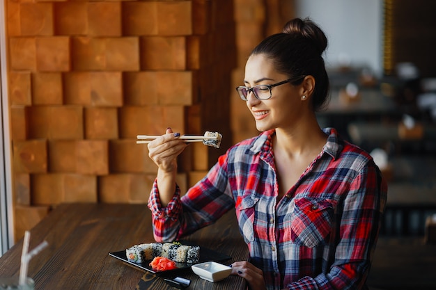 Ragazza mangiando sushi al ristorante