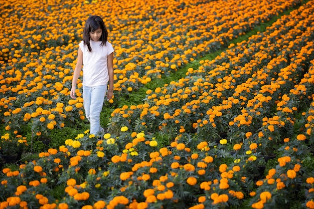 Ragazza messicana che cammina attraverso un campo di fiori di cempasuchil a Xochimilco