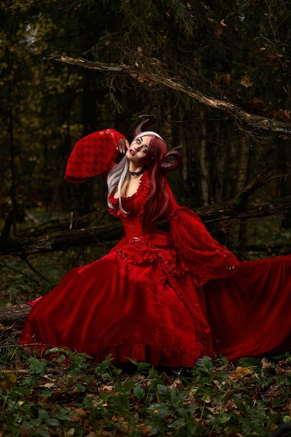 Ragazza modello elegante e alla moda nell'immagine di Malefica in posa tra la foresta mistica - storia da favola, cosplay. Halloween.