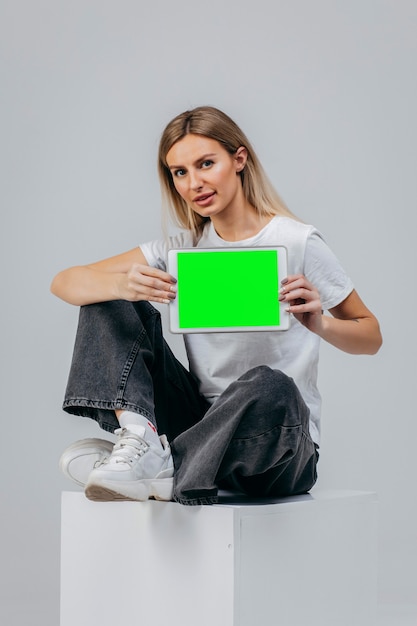 Ragazza moderna in maglietta bianca con tablet in studio Creatività libera