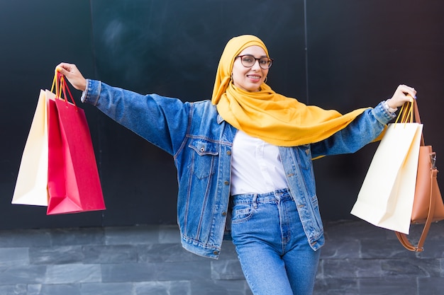 Ragazza musulmana araba felice con le borse della spesa