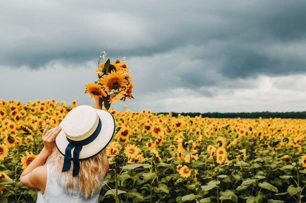 Ragazza nel campo di girasoli mentre piove