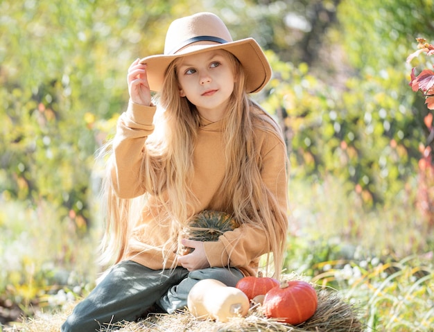 Ragazza nel fieno con le zucche