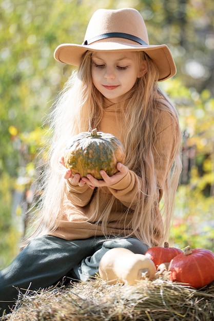 Ragazza nel fieno con le zucche