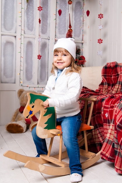 Ragazza nel giorno di Natale con il giocattolo del cavallo