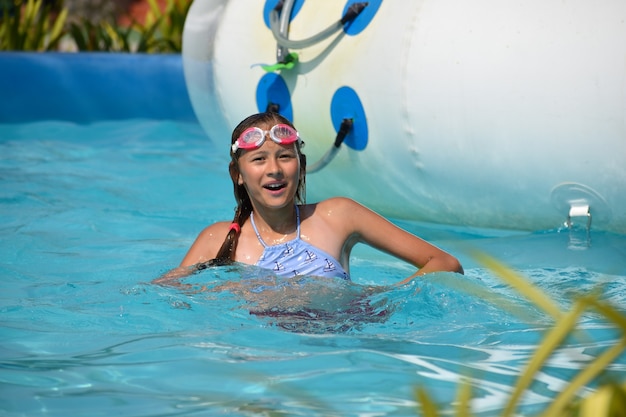 Ragazza nel parco acquatico. Divertimento sull'acqua.