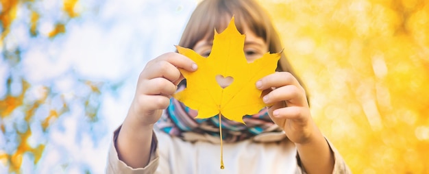 Ragazza nel parco con foglie d'autunno.