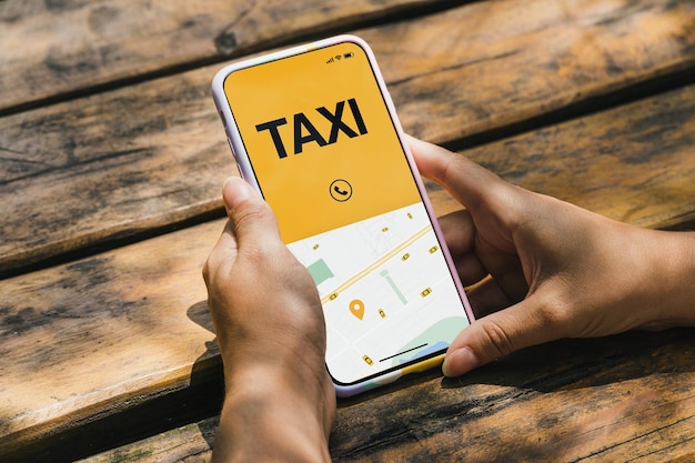 Ragazza nel parco con in mano uno smartphone con l'app Taxi Service sullo schermo. Tavolo in legno rustico. Fornitore di servizi di mobilità in tutto il mondo.