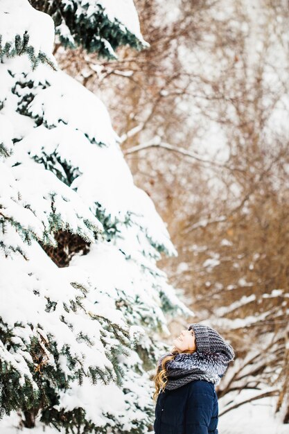 Ragazza nel parco di inverno coperto di neve