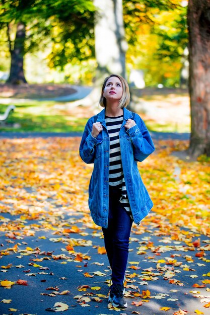 Ragazza nel parco di stagione di autunno