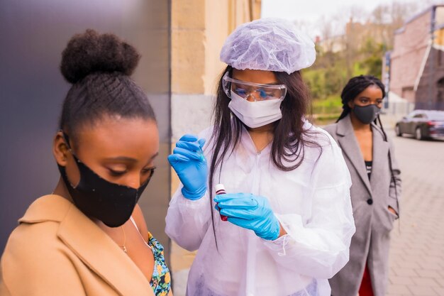 Ragazza nera che riceve l'iniezione del vaccino contro il coronavirus da un medico covid19