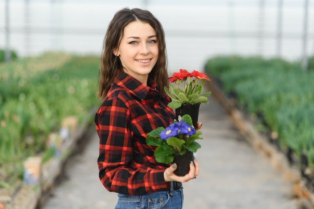 Ragazza, operaia con fiori in serra