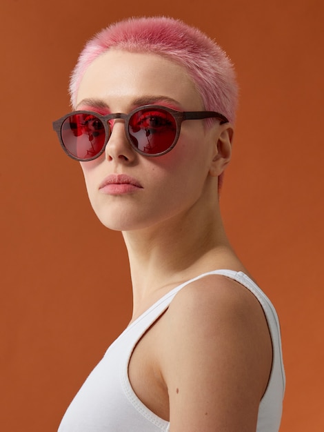 Ragazza pinkhead hipster in occhiali da sole rossi