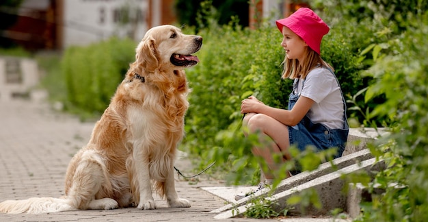 Ragazza preadolescente con cane golden retriever