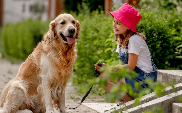 Ragazza preadolescente con cane golden retriever