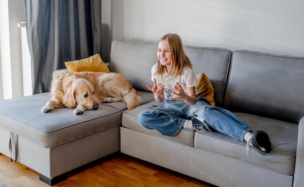 Ragazza preteen con il golden retriever a casa