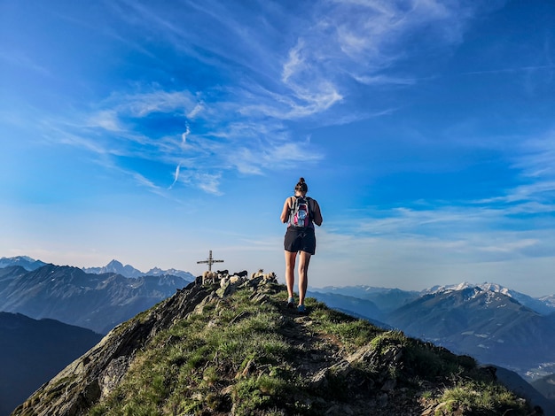 Ragazza rampicante in montagna con cielo blu