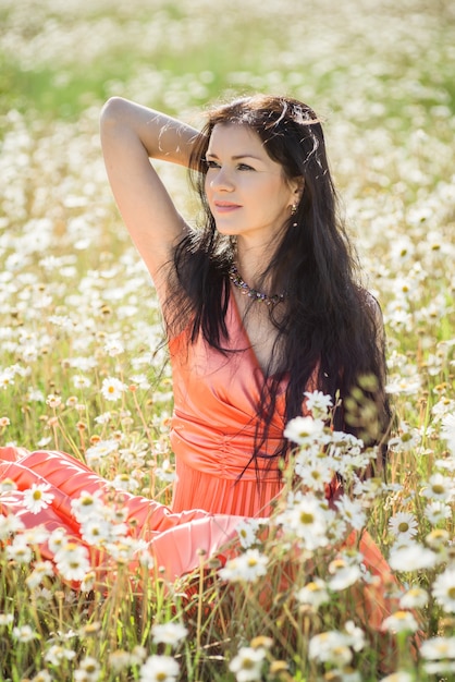 Ragazza romantica di bellezza all'aperto. Bella ragazza modello adolescente vestita in abito corto casual sul campo alla luce del sole. Capelli lunghi che soffiano. Autunno. Sole splendente, sole. retroilluminato. Tonica con colori caldi.