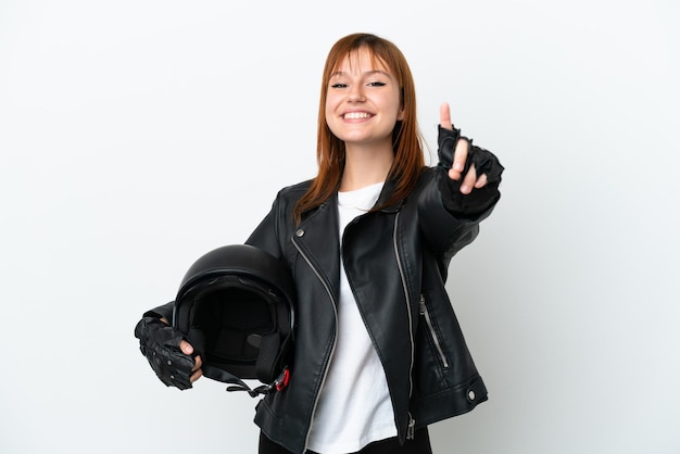 Ragazza rossa con un casco da motociclista isolato su sfondo bianco che mostra e alza un dito