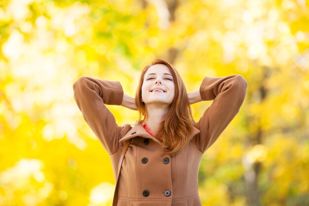 Ragazza rossa nel parco d'autunno