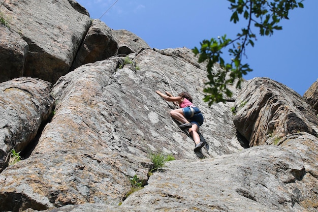 Ragazza scalatore si arrampica su una roccia