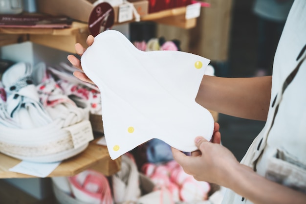 ragazza sceglie assorbenti mestruali di stoffa in un negozio senza plastica assorbente femminile riutilizzabile in un negozio a zero rifiuti