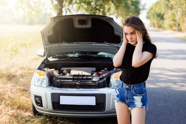 Ragazza sconvolta che fa facepalm a causa del guasto alla sua auto