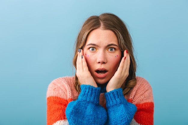 Ragazza scossa che indossa maglione in piedi isolato