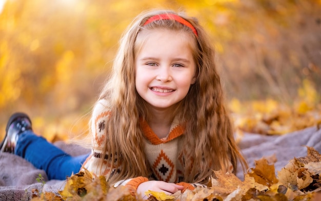 Ragazza sdraiata nel parco autunnale