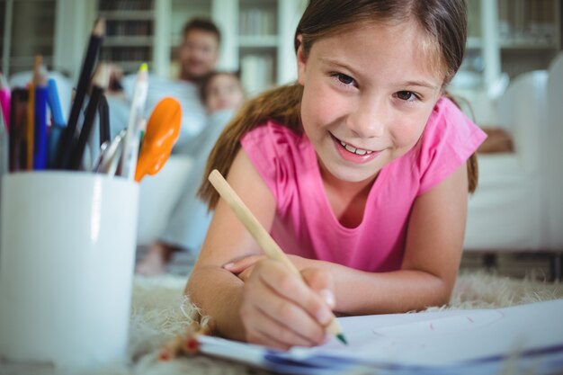 Ragazza sdraiata sul pavimento e disegno